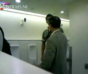 Op de heren toilet trekt de jonge man zijn stijve lul af, terwijl zijn camera het op neemt en andere mannen toe kijken. Amateur , Afrukken terwijl andere mannen toe kijken in het toilet